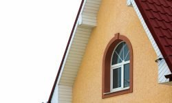 Low angle view of the upper floors of a new large house. Window and roof detail of residential home building. Real estate property.